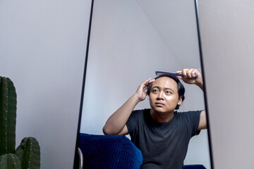 Portrait of a man struggling with alopecia seen through a mirror reflection