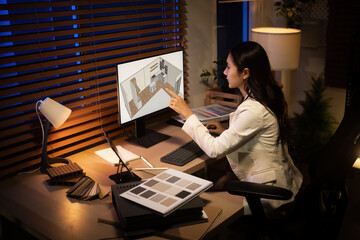 Focused professional reviewing a 3D rendering of a kitchen extension, combining technology and creativity in a home office at night