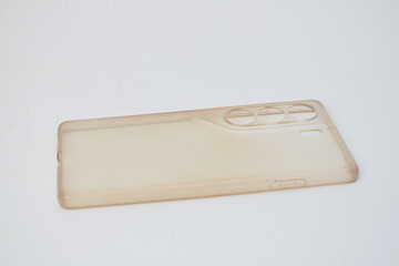 Old yellowed transparent silicone smartphone case isolated on a white background. Ideal for topics about phone accessory wear, aging materials, or product replacement