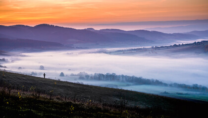 ide landscape of lone military soldier standing guard on hill overlooking misty valley at dawn