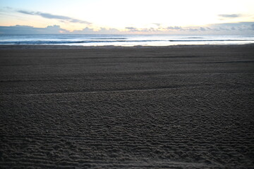Obraz premium A corduroy-textured beach in the morning with empty space and visible beach shower hydrants 