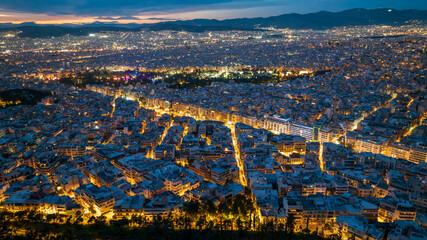 Drone photo of downtown Athens, Greece at dusk with city lights on