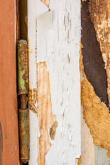 Close up of peeling cracked paint on an old weathered wooden surface, showing texture, decay, and natural aging details. Perfect for backgrounds, overlays, and rustic grunge design elements.