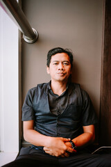 Casual portrait of a man in black attire sitting down