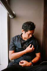 Thoughtful man sitting quietly indoors with a pensive expression