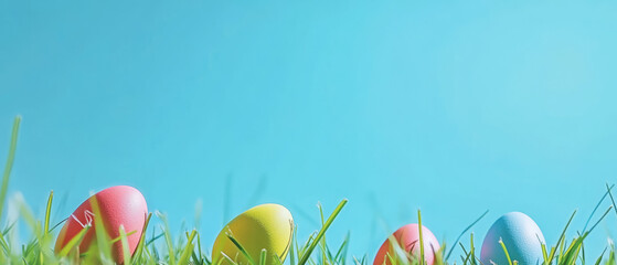 Vibrant painted eggs are nestled in lush green grass against a clear blue sky, creating a cheerful and festive seasonal background with ample space for custom text or holiday banner designs.