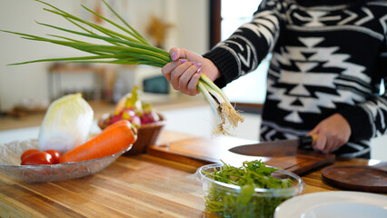 Woman Preparing Fresh Spring Onions For Culinary Use