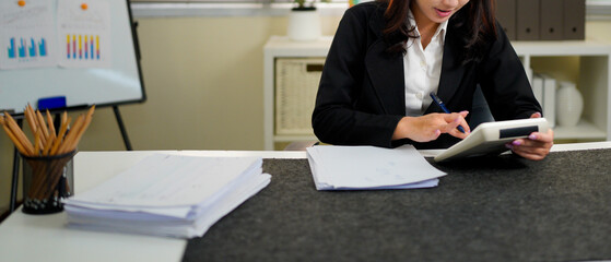 businesswoman using a calculator to calculate the numbers for financial document, finance accounting concept
