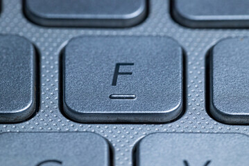 Close-up macro view of the "F" keys on a gray laptop keyboard with detailed texture and selective focus.