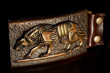 forged belt badge hand craft object with wolf form folk symbol close up view