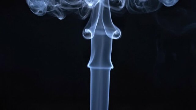 A captivating column of delicate, wispy white and blue smoke rises gracefully against a deep, dark background. The fluid motion creates intricate, evolving patterns as the vapor expands and slowly dis
