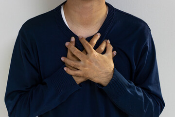胸を押さえる男性。病気のイメージ（日本人、顔無し、30代）