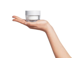 Woman's hand presenting a transparent jar filled with white beauty cream on a clean background, symbolizing skin care, hydration, and dermatology treatment for daily routine