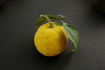 yellow ripe yuzu fruit on a black background