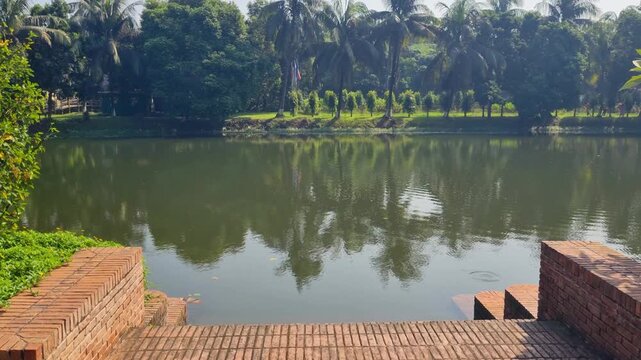 Picturesque pool before a colonial-era mansion amid lush tropical greenery in Panam Nagar, Sonargaon, Bangladesh, captured on a sunny day
