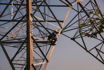 Electrical engineers climb high voltage power poles for maintenance.