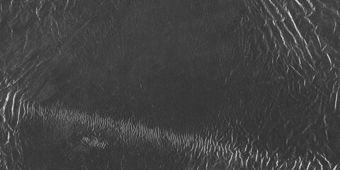 Wrinkled plastic wrap texture on a black background. Cellophane package wallpaper