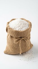 chunky white crystalline sea salt spilling from a rustic tan burlap bag tied with twine