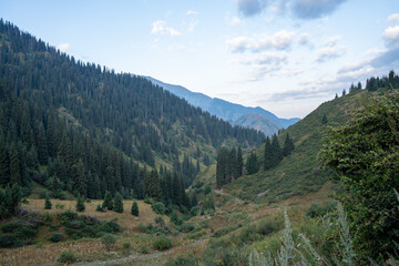 Obraz premium Panoramic mountain landscape of Trans-Ili Alatau range, Almaty, Kazakhstan. Hiking trail to Furmanov and Panorama peaks above 3000 meters in Tien Shan, Central Asia.