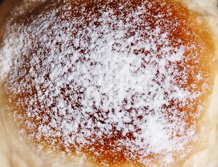 Powdered sugar pastry bun. Close up dessert.