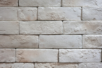 White brick wall with roughly surface. Building structure and interior decoration, background texture. Close-up.