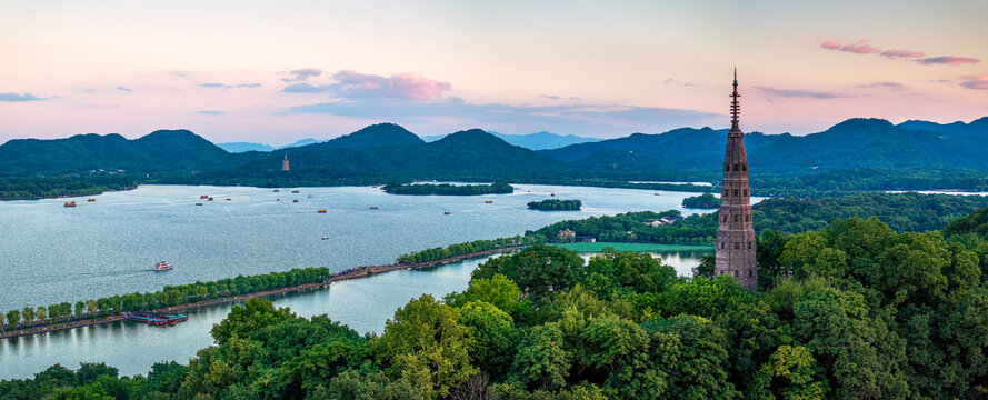 Aerial view of the West Lake with pagodas and mountains at sunset in Hangzhou, China.