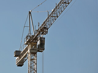 Tower cranes work during the construction of a multi-story building. New apartments for residents and premises for offices. Risky work at height. Lifting heavy building materials. City development