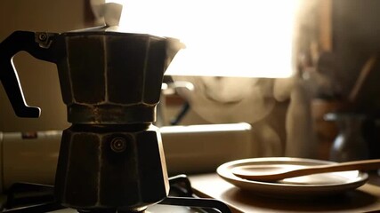 Crafting Delicious Coffee: Close-Up of Moka Pot Steaming on Kitchen Stove with Sunlight Streams