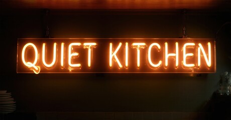 Fototapeta premium Bright neon sign displays Quiet Kitchen. Warm glow illuminates dark kitchen background. Simple, modern aesthetic.