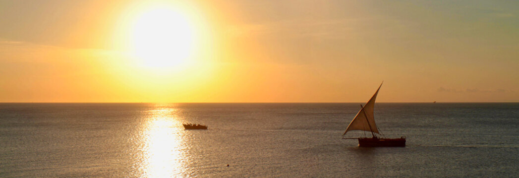 Traditional Dhow Sailboat Silhouetted Against Golden Sunset Over the Indian Ocean, Zanzibar, Tanzania &mdash; Panoramic Seascape
