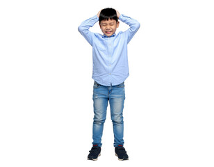 Playful boy in light blue shirt and jeans covering his ears with a surprised expression