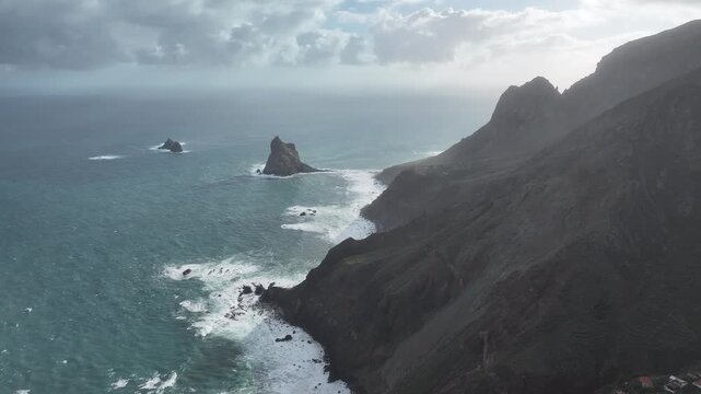 Aerial view of the rugged coastline meeting the turquoise ocean near Roque de las Animas, creating a stunning contrast of colors, Tenerife, Canary Islands, Spain.