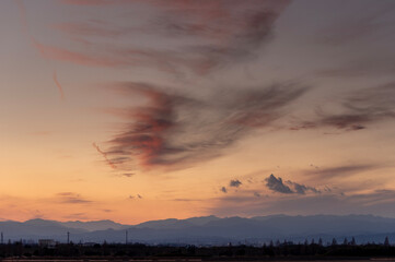 冬の夕暮れに染まる秩父連山と空を流れる雲の風景