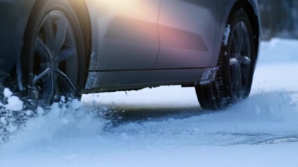 A car driving on a snow-covered road, the tires creating a trail of ice and snow Stock Video