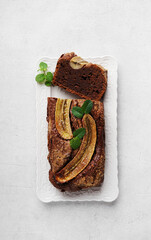 Homemade banana bread with mint leaves close-up on table. Vertical top view