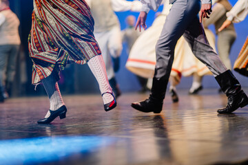 Latvian folk dancers showcase vibrant traditional costumes and rhythmic movements on stage, celebrating cultural heritage through lively performance art