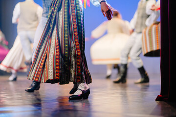 Latvian folk dancer in traditional attire showcasing vibrant patterns and rhythmic movements on stage during a cultural performance celebration