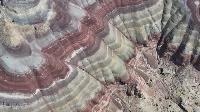 Aerial view of the layered geological formations, where stripes of red, brown, and grey create a visually stunning landscape, Caineville, Utah, United States.