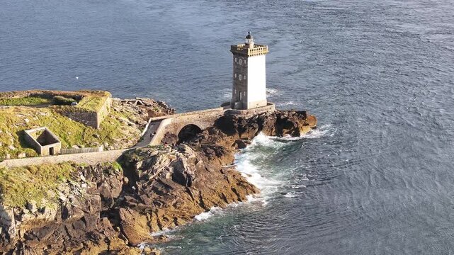 Aerial view of Petit Minou lighthouse, a beacon of white stone standing defiant against the crashing waves, Bretagne, France.