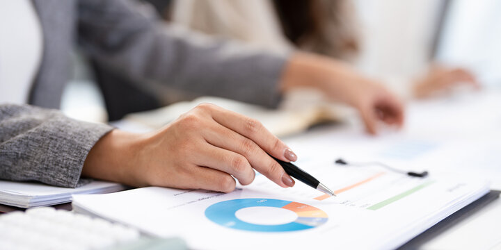 close up hands of Business partners working with analysis report and advisor showing plan, Two businesswoman working with Financial analysts reports and planning investment at office.