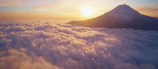 Majestic mountain peak piercing through a sea of serene clouds at sunrise