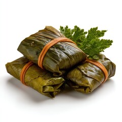 Delicious wrapped food in green leaves tied with rubber band placed on a wooden table with a fresh herb garnish