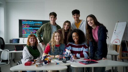 High school students working on robotics project. Girl in wheelchair among them. - Powered by Adobe
