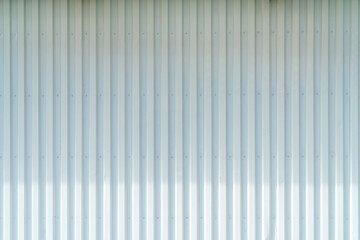 White corrugated metal wall background texture with vertical lines and rivets. Clean industrial...