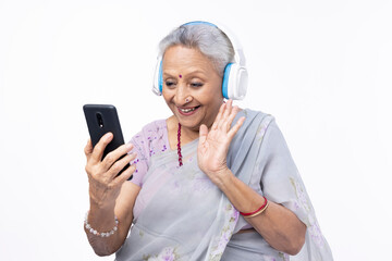 Elderly Indian Woman Using Video Call on Smartphone: Talking Long-Distance Friends, Smiling. Joyful Smiling Senior Lady Talking to Her Family, Relatives, Grandchildren. Closeup