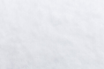 Obraz premium Snow covers trees and the ground in a natural area. The scene shows a bright sky with clouds and a cold winter atmosphere. Trees appear laden with snow