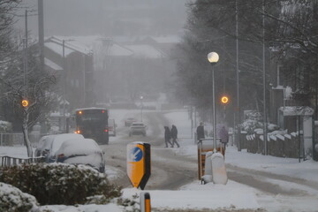 Aberdeen Scotland 3rd January 2025 Snow covered main road roundabout with in a snowy neighbourhood background. Bus and pedestrians crossing the road.Snow storm 
