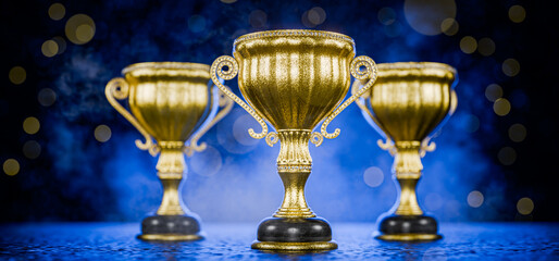 First place in a computer game. Victory. Goal achievement concept. Award for outstanding achievement. Golden winner's cups as awards on a blue background. Achievements. Winner's certificate. 3D render