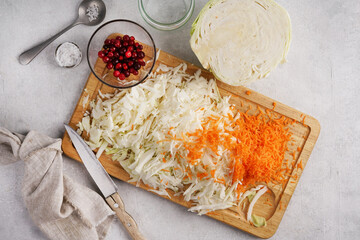 Pickling cabbage with carrot at home on table. Prepare homemade sauerkraut or fermented cabbage with carrot. top view