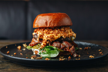 Fresh craft beef burger with bacon and cheese sauce on the rustic wooden table